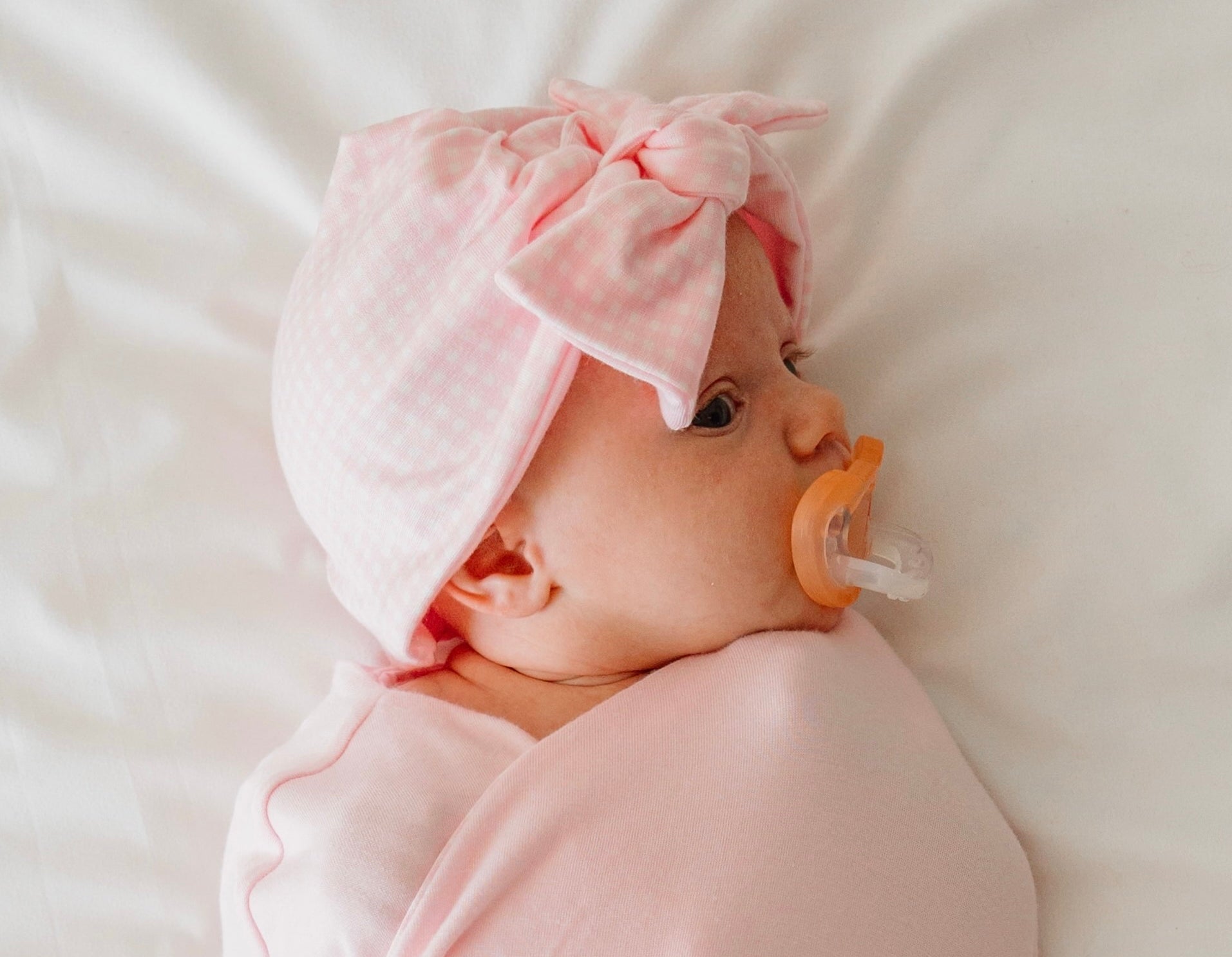 Reversible newborn essentials bundle with flutter sleeves in silky modal fabric with baby pink gingham design.