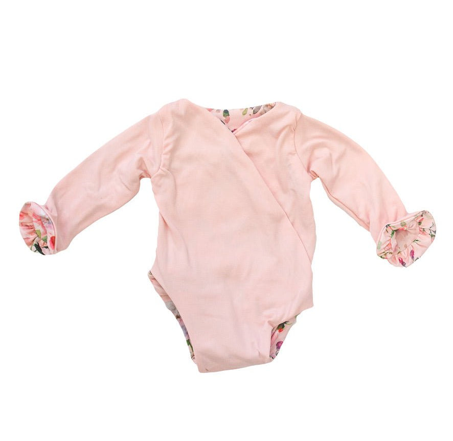 Reversible winged long sleeve infant bodysuit crafted from cozy Peachy Rose Fields design brushed fabric with ruffle cuffs.
