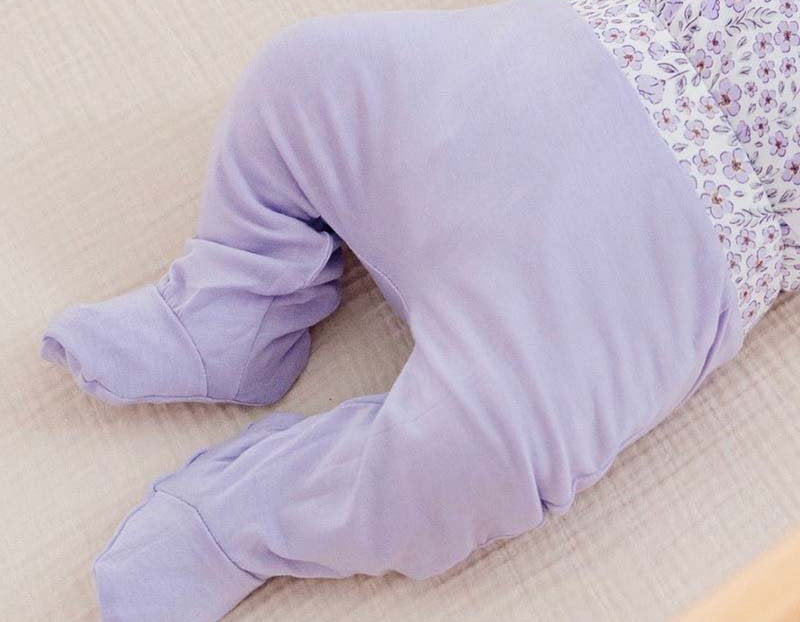 Reversible baby footie pants crafted from a soft silky modal fabric featuring the Purple Posies print.
