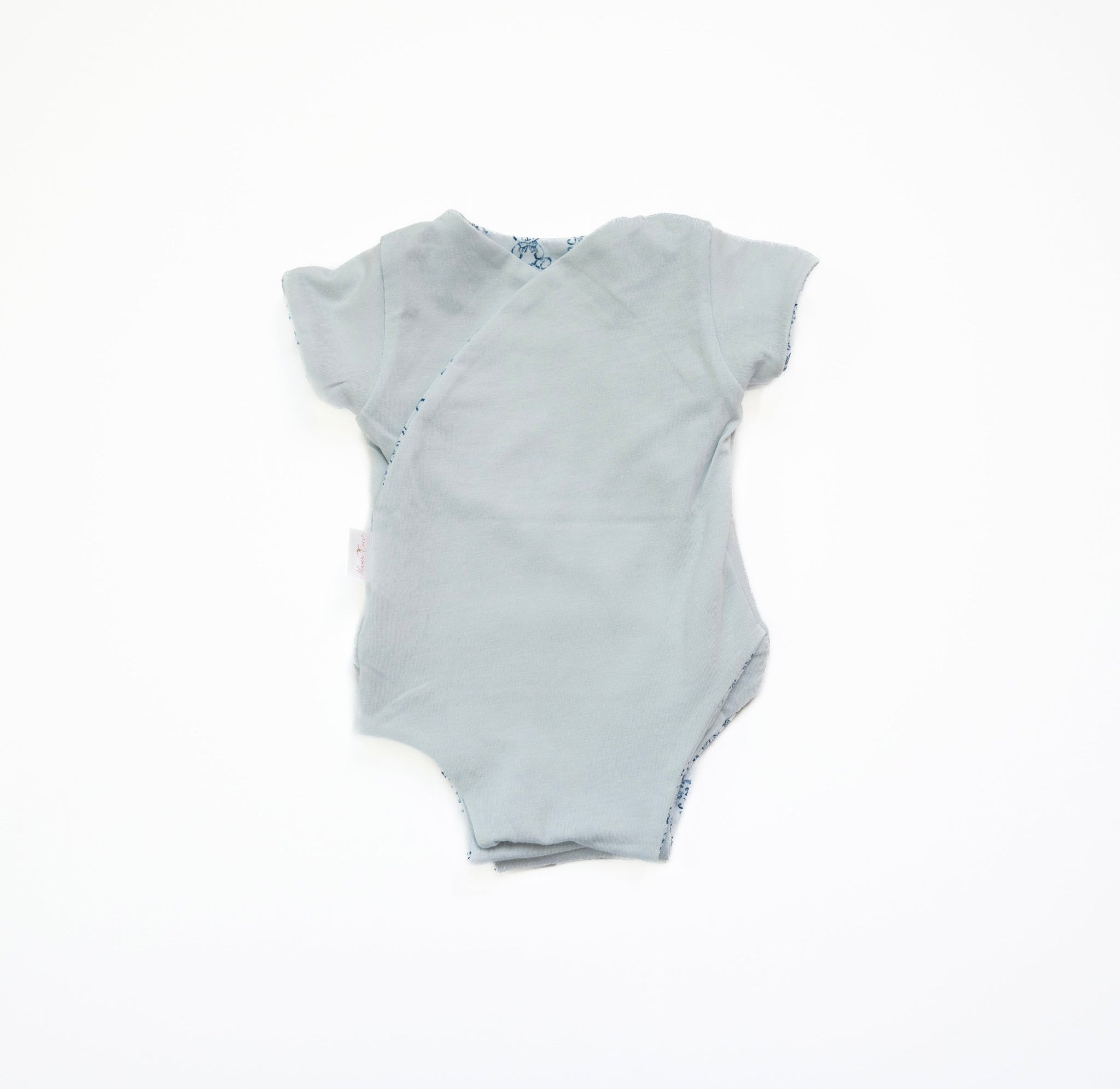 Reversible short-sleeve baby onesie in teddy tiles design.