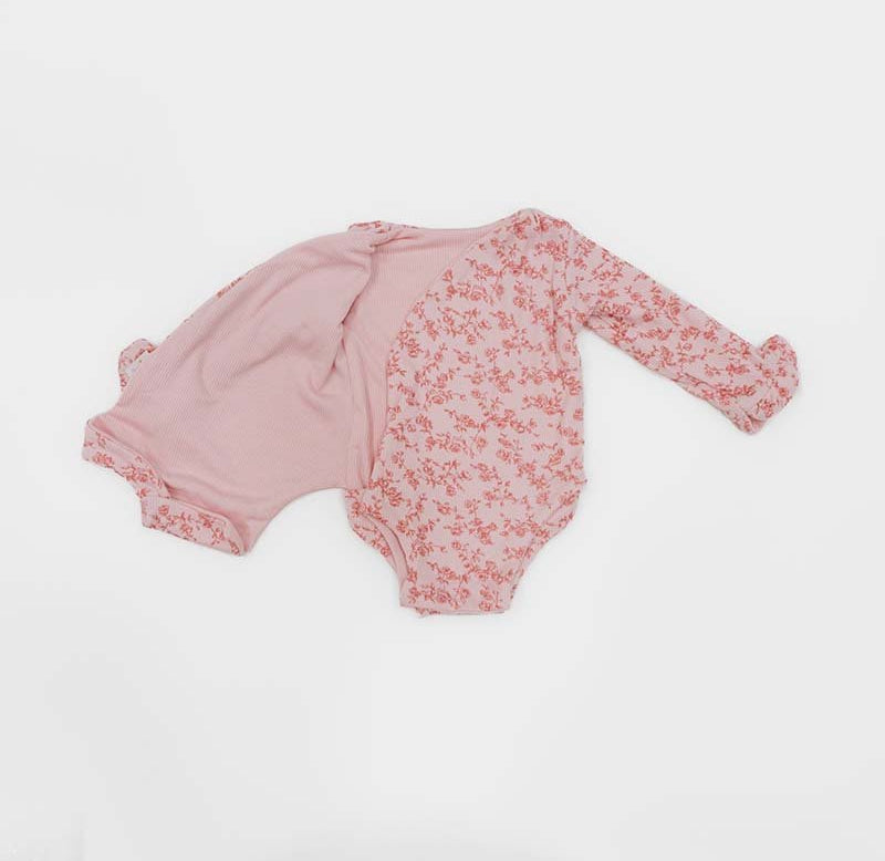 Reversible Bitty Pink Blooms design ruffle cuff long sleeved winged bodysuit in silky modal fabric.