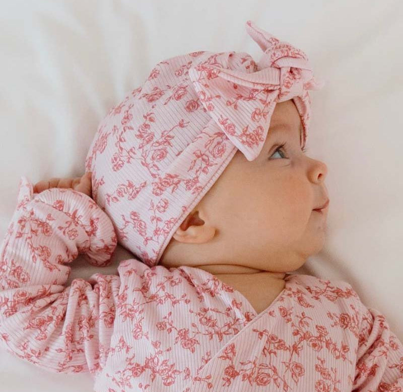 Ruched baby beanie with bow in Bitty Pink Blooms design, made from Silky Modal fabric.