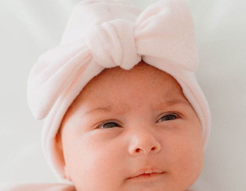 Ruched beanie with bow in Plush Pink Cashmere design, made from Plush Dream fabric.