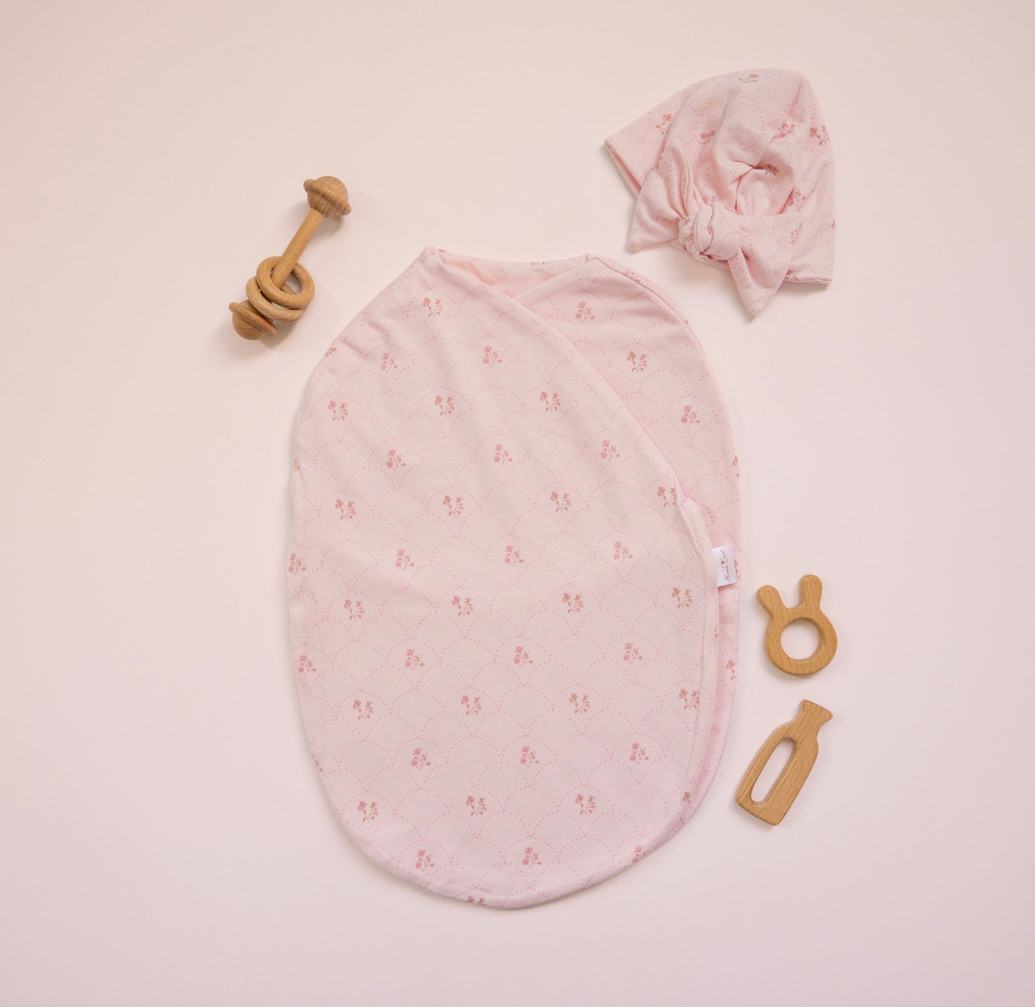 Bamboo cotton baby beanie with ruched bow in dainty dots design. Shown with matching cocoon swaddle.