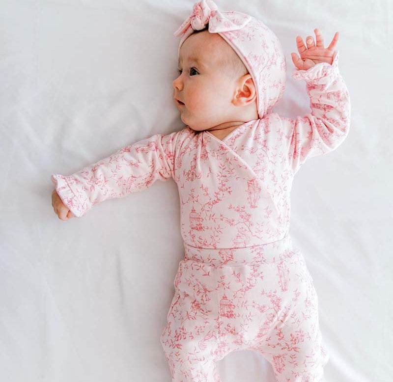 Reversible ruffle cuff long sleeve baby onesie made from bamboo cotton.