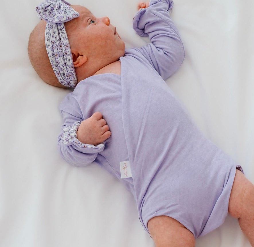Reversible long sleeved winged bodysuit for babies in silky modal fabric with ruffle cuffs.
