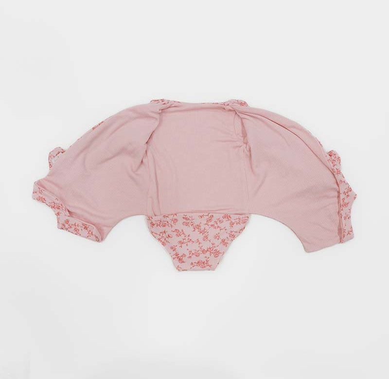 Reversible long sleeved winged bodysuit for babies in silky modal fabric with ruffle cuffs.