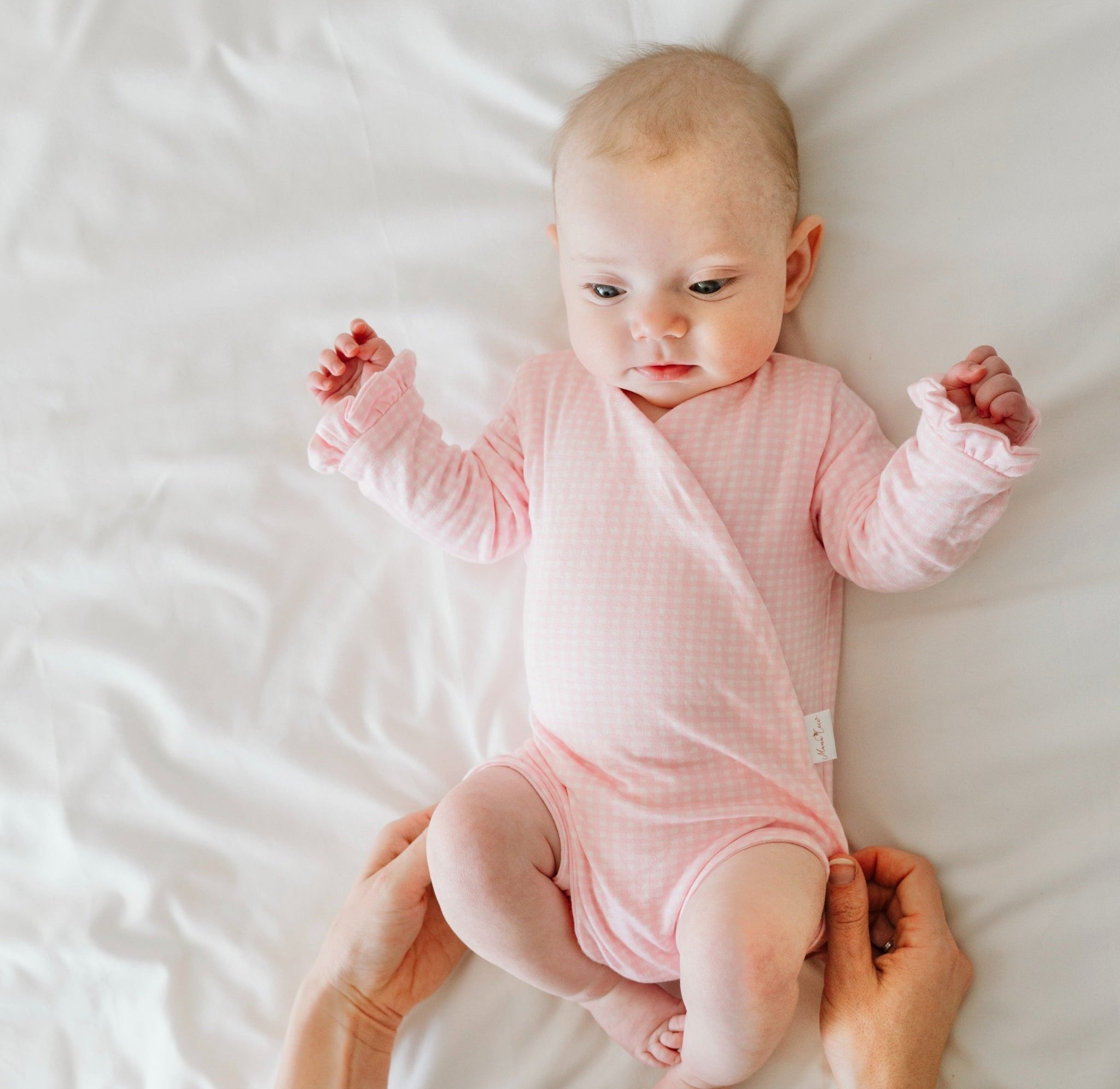 Ruffle cuff baby winged bodysuit with long sleeves in Baby Pink Gingham design.