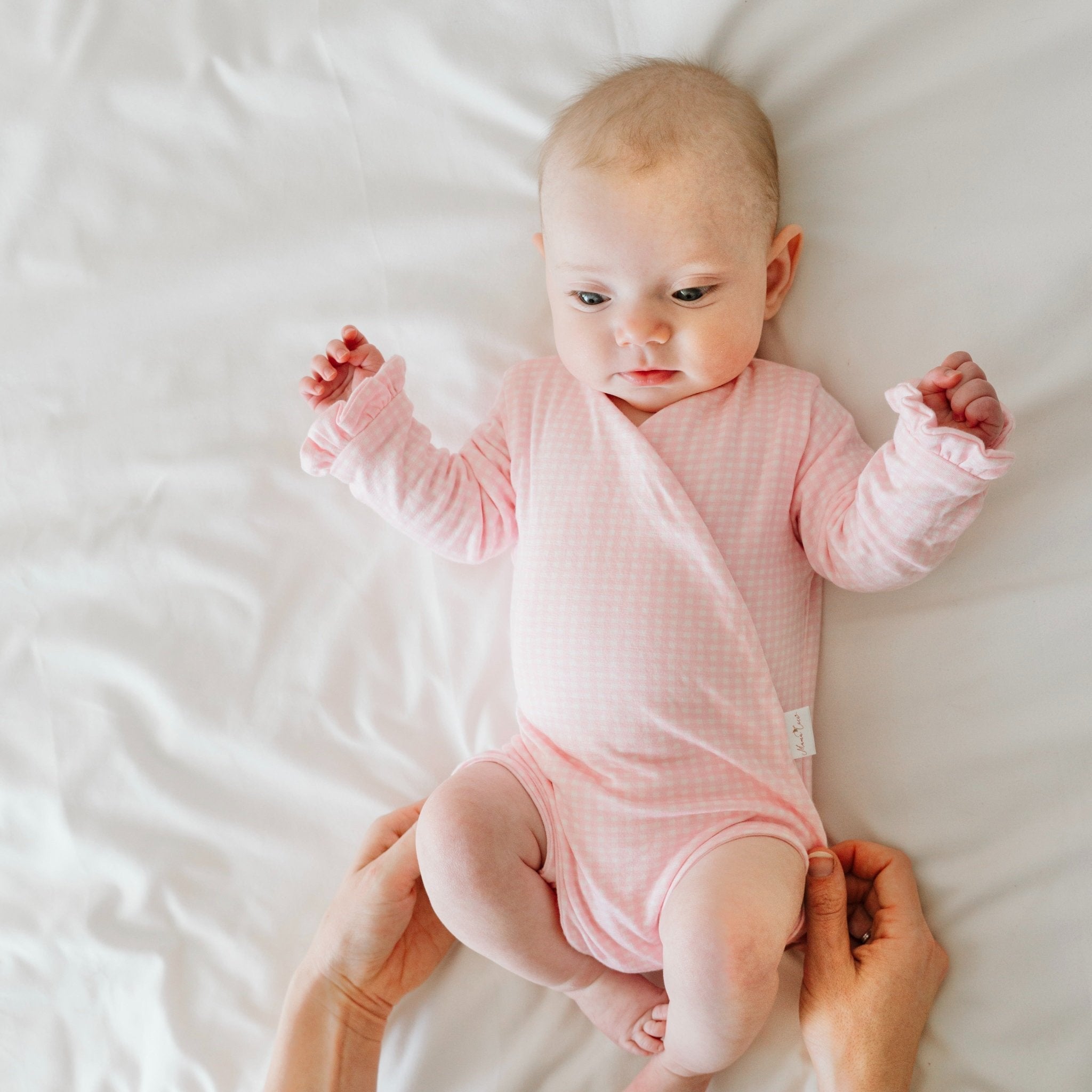 Ruffle cuff baby winged bodysuit with long sleeves in Baby Pink Gingham design.