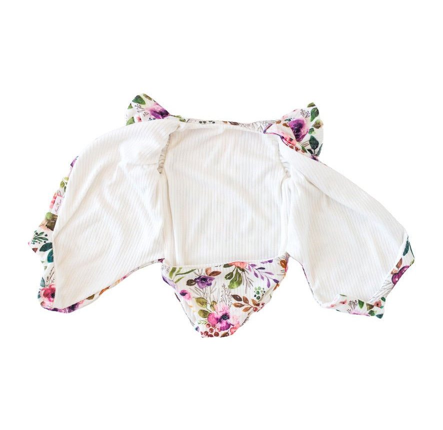 Reversible boutique baby bodysuit in Ivory Wildflowers print and Classic Brushed fabric styles.