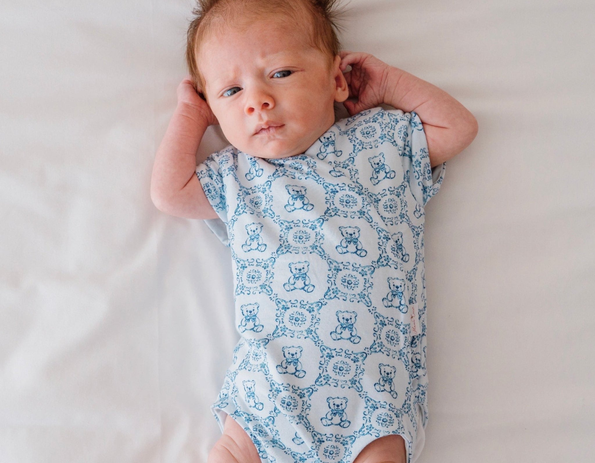 Short-sleeve winged bodysuit for babies in bamboo organic cotton, with teddy tiles design.
