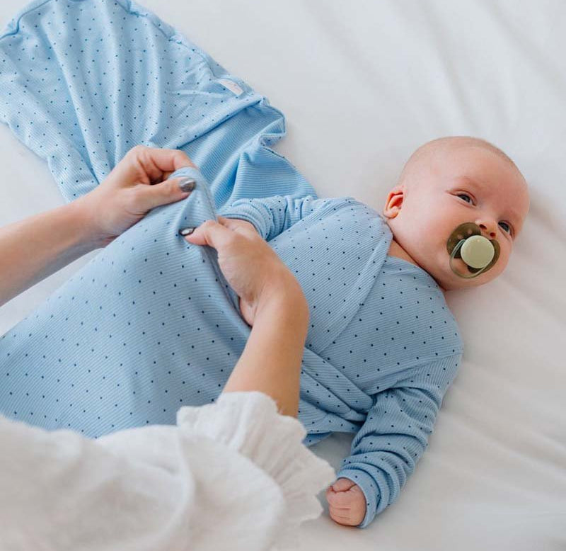 Soft Dotted Blues design on a Cocoon swaddle baby blanket in Silky Modal fabric styles.