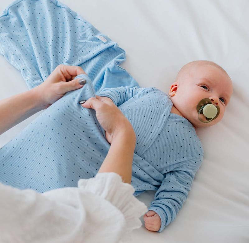 Soft Dotted Blues design on a Cocoon swaddle baby blanket in Silky Modal fabric styles.