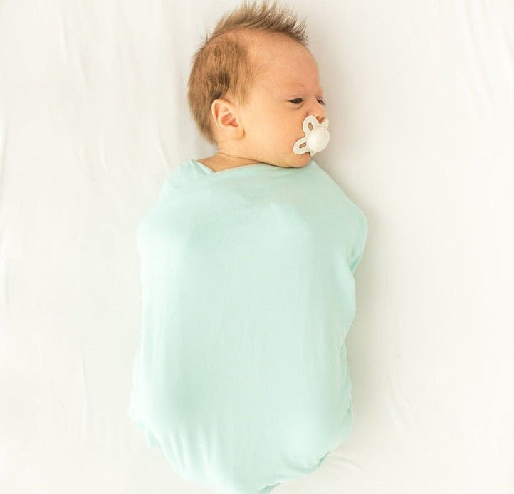Newborn baby cocoon swaddle featuring Honeydew Palms Silky Modal fabric.