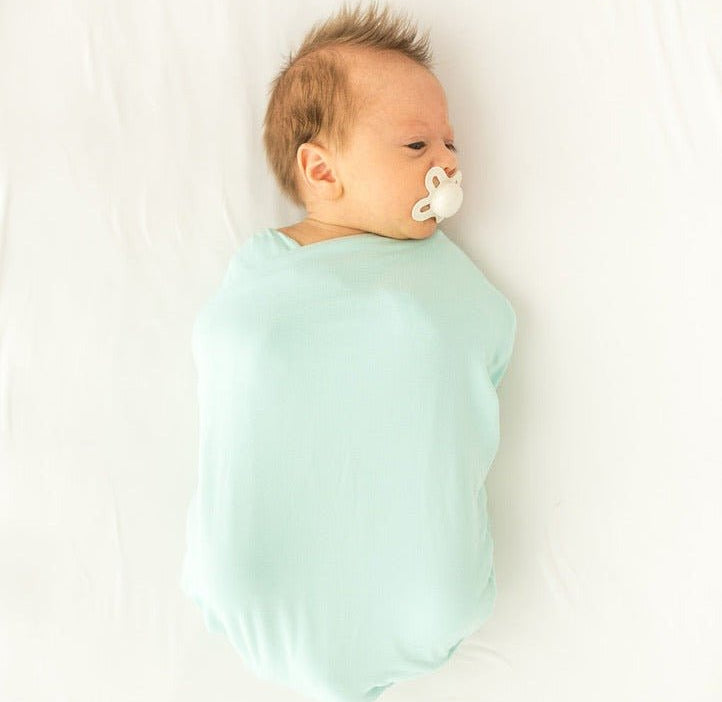 Newborn baby cocoon swaddle featuring Honeydew Palms Silky Modal fabric.
