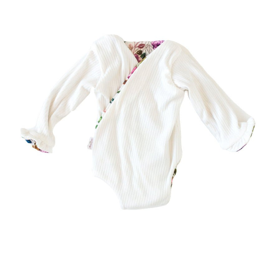 Winged long sleeve infant bodysuit crafted from cozy Ivory Wildflowers design reversible brushed fabric with ruffle cuffs.
