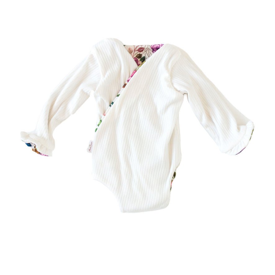 Winged long sleeve infant bodysuit crafted from cozy Ivory Wildflowers design reversible brushed fabric with ruffle cuffs.
