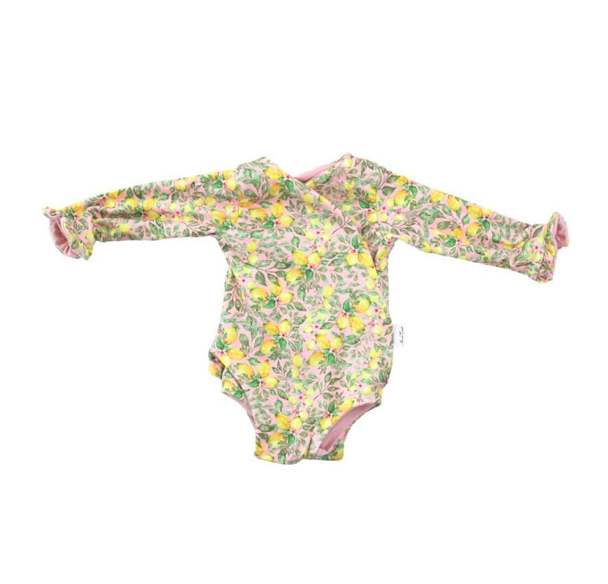 Winged long sleeve infant bodysuit crafted from cozy Pink Lemonade design brushed fabric with ruffle cuffs.