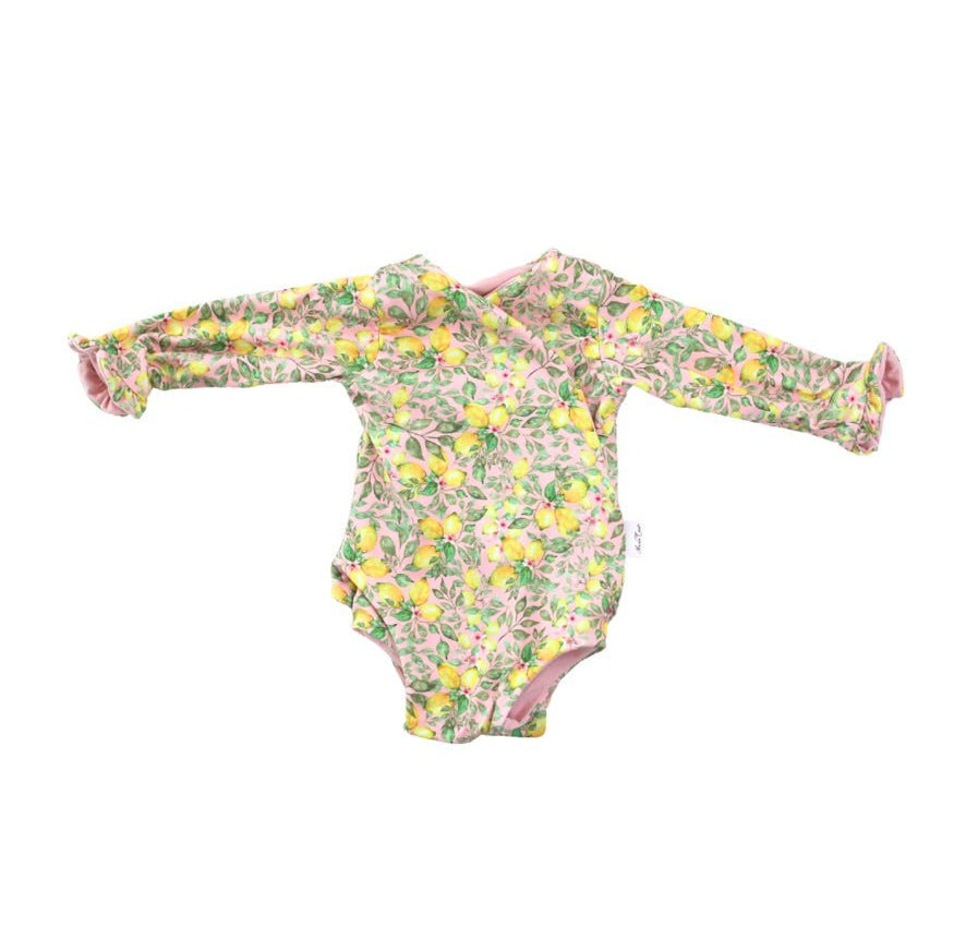 Winged long sleeve infant bodysuit crafted from cozy Pink Lemonade design brushed fabric with ruffle cuffs.