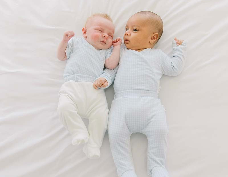 Two babies wearing our silky modal footie pants in Baby Blue Gingham design.