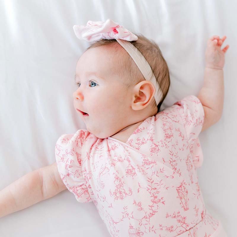 Flutter sleeve winged bodysuit for babies in whimsical garden design.