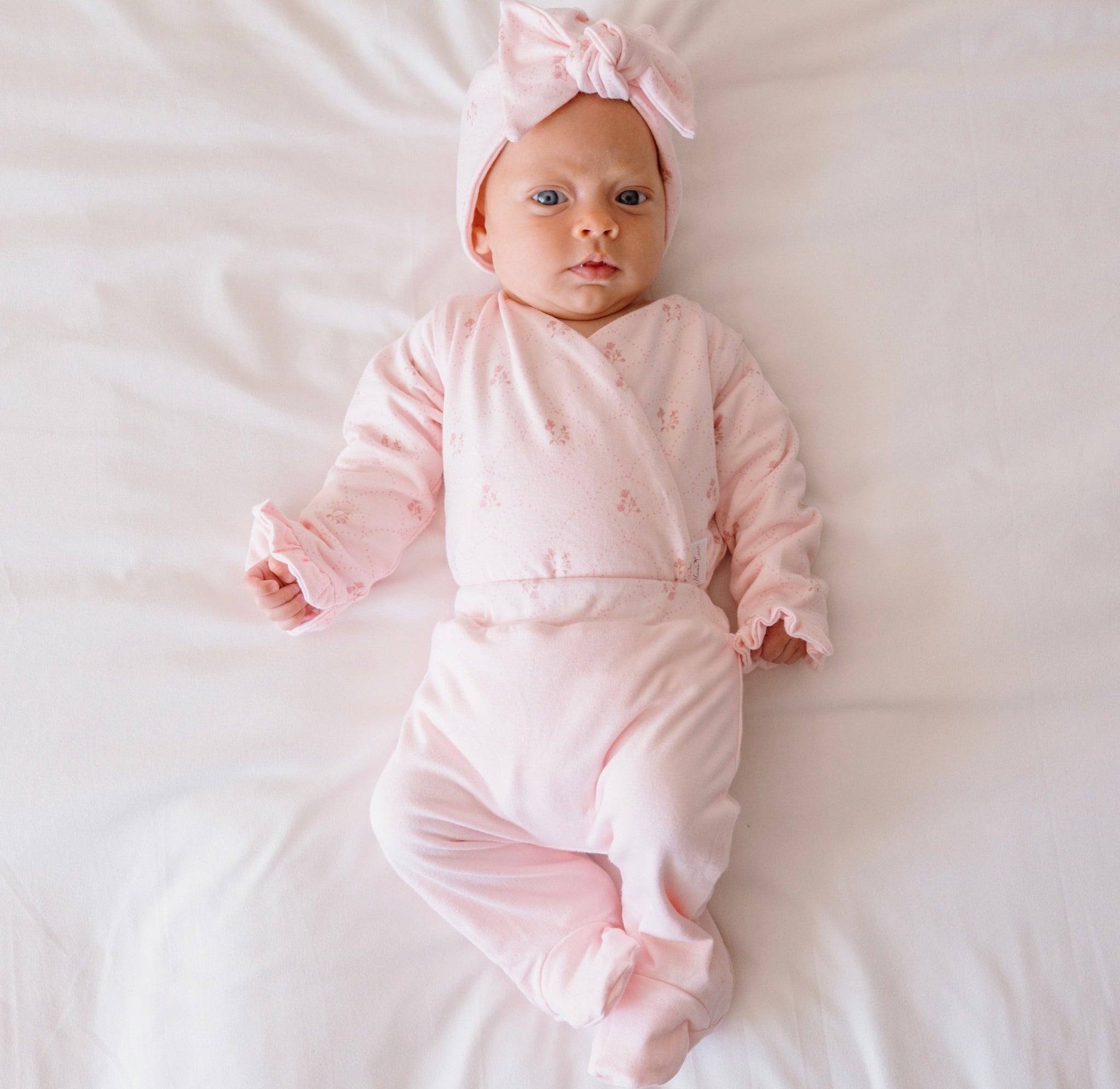 Reversible ruffle cuff long sleeve baby onesie made from bamboo cotton.