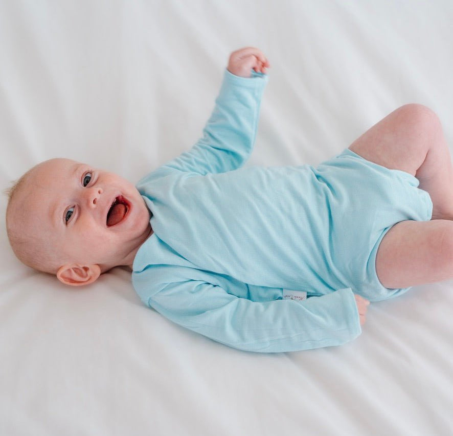 Long-sleeved reversible winged bodysuit for babies in silky modal fabric.