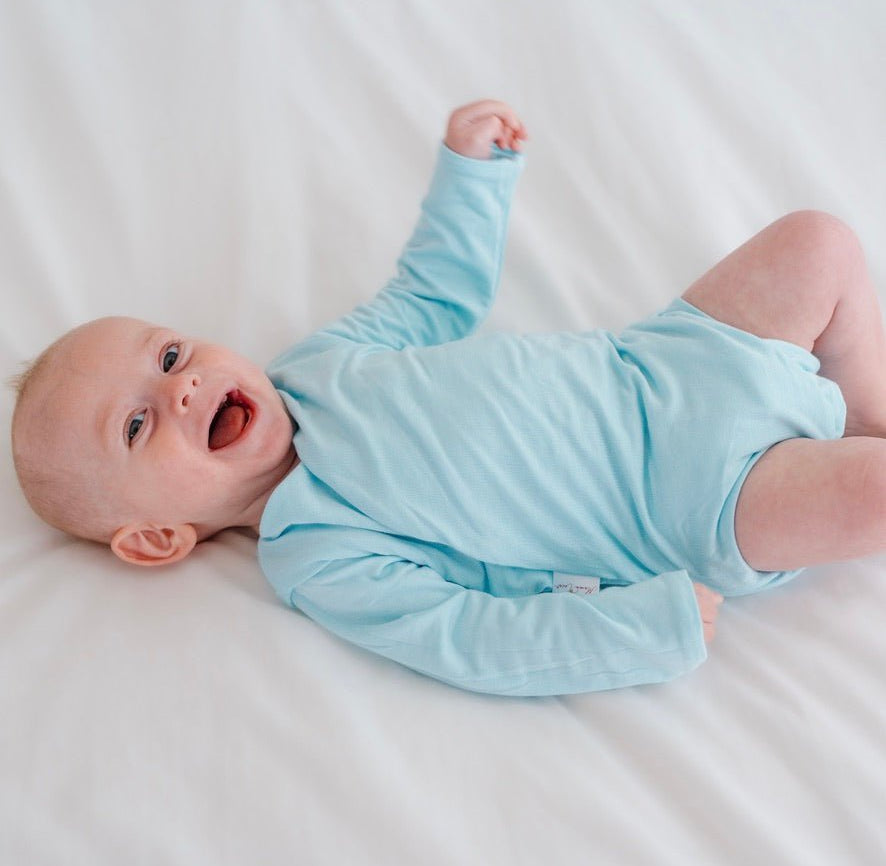 Long-sleeved reversible winged bodysuit for babies in silky modal fabric.
