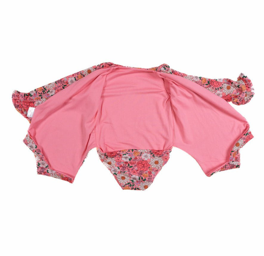 Winged long sleeve infant bodysuit crafted from cozy Flower Power design reversible brushed fabric with ruffle cuffs.