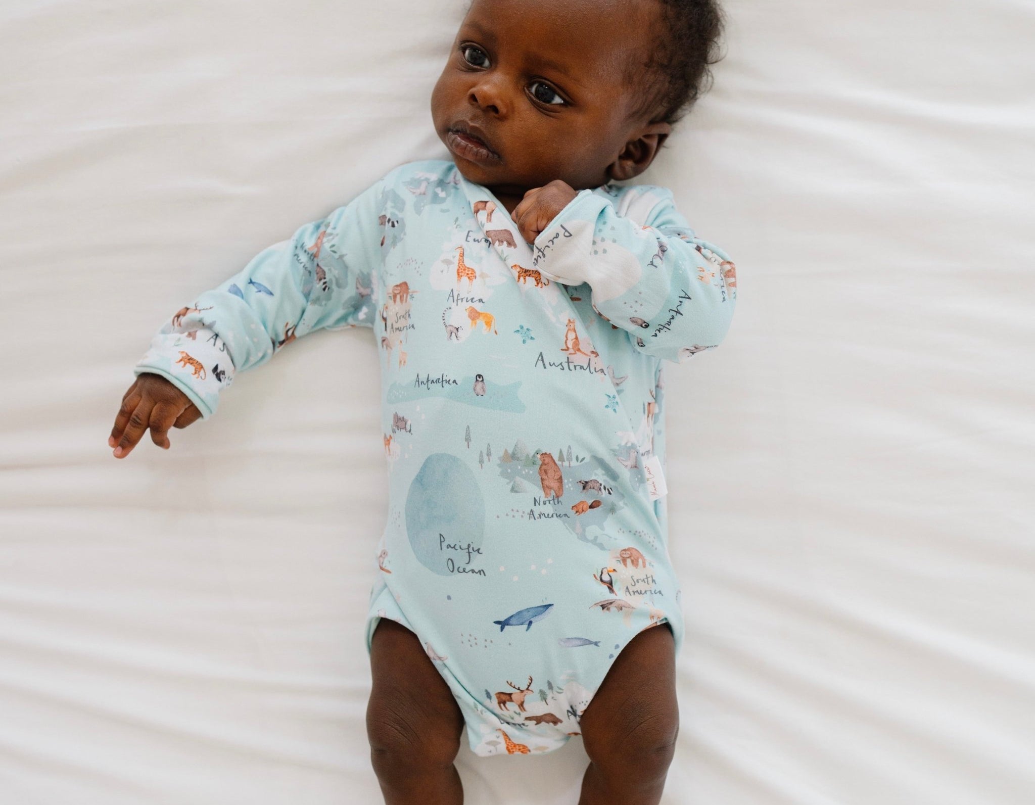 World traveler design long-sleeve baby onesie in classic brushed fabric.