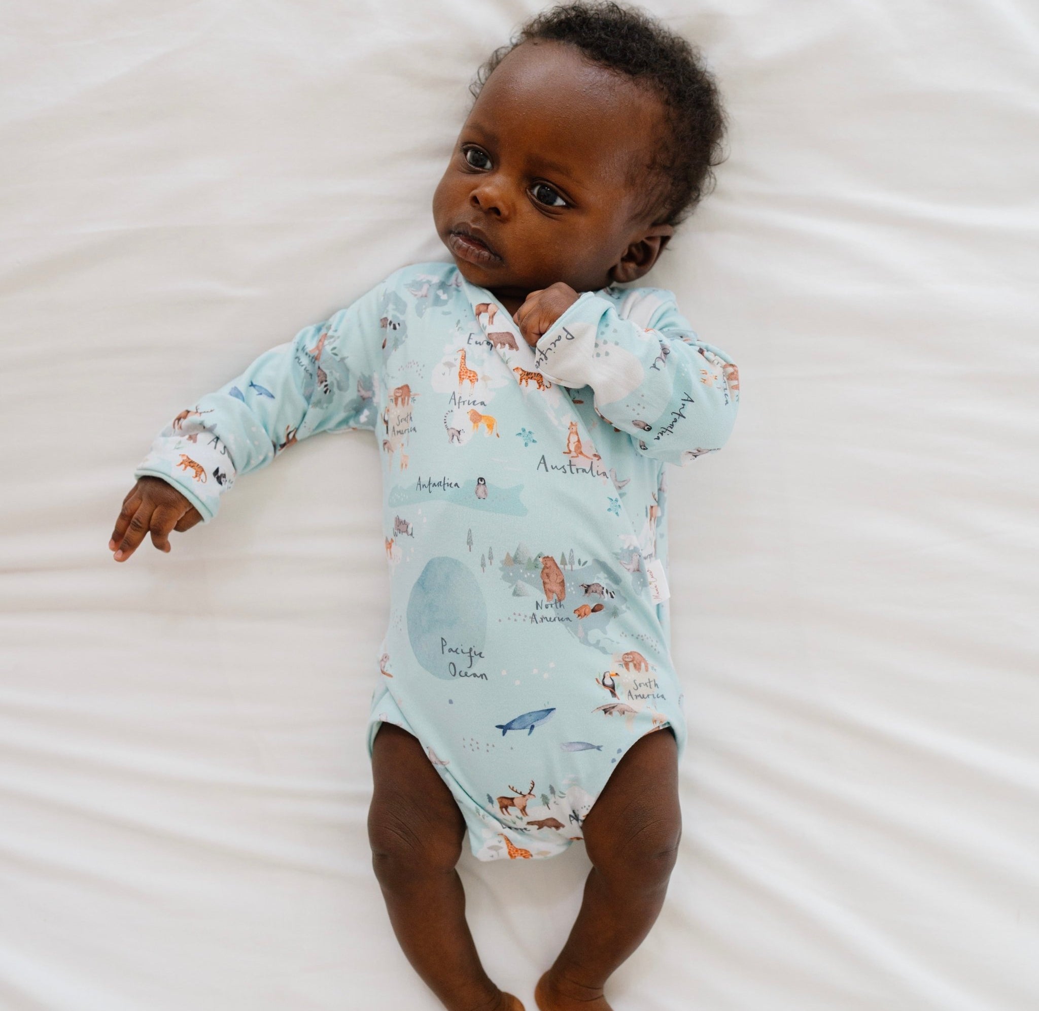 World traveler design long-sleeve baby onesie in classic brushed fabric.