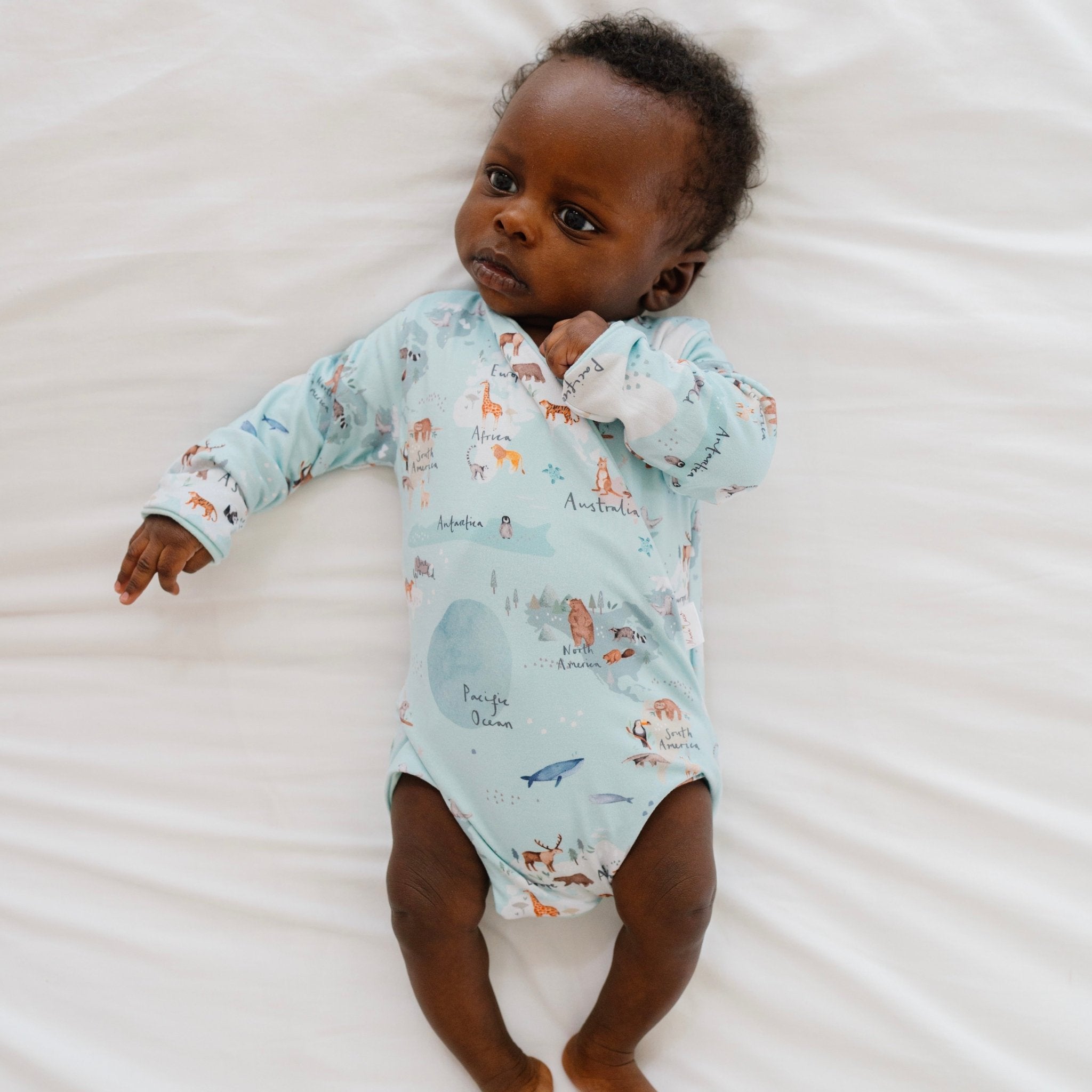World traveler design long-sleeve baby onesie in classic brushed fabric.