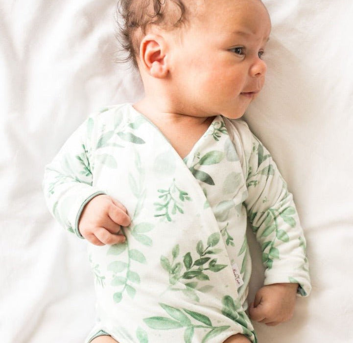 Reversible long-sleeve winged bodysuit in saged eucalyptus design.