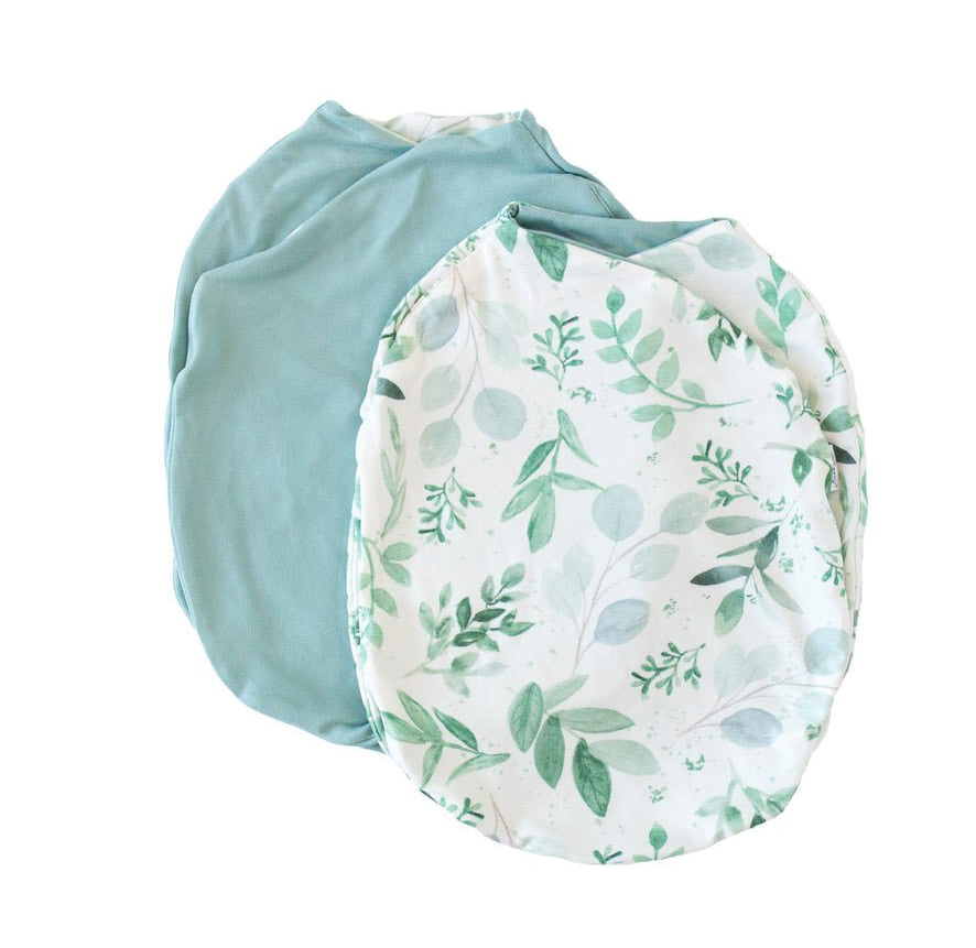 Reversible baby cocoon swaddle in saged eucalyptus design.