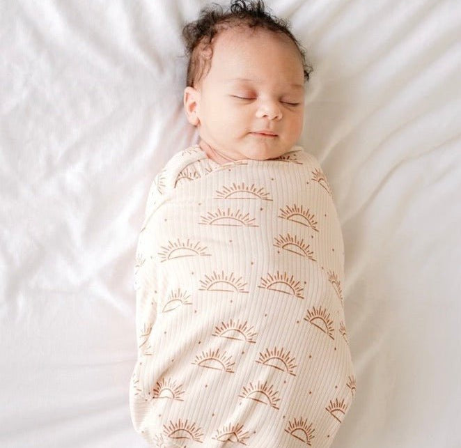 Soft baby cocoon swaddle made from Silky Modal in the Sandy Sunsets design.