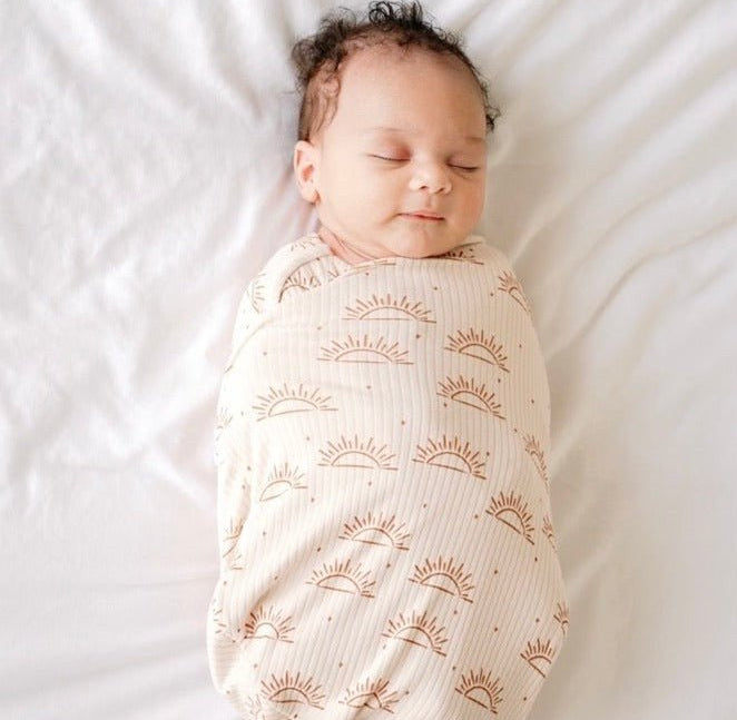 Soft baby cocoon swaddle made from Silky Modal in the Sandy Sunsets design.