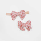 Bitty Pink Blooms headbands for babies, featuring a stylish bow detail.