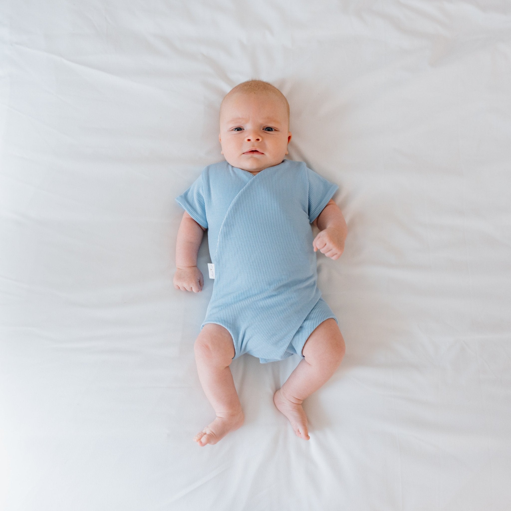 Reversible short-sleeve baby winged bodysuit in dotted blue design.