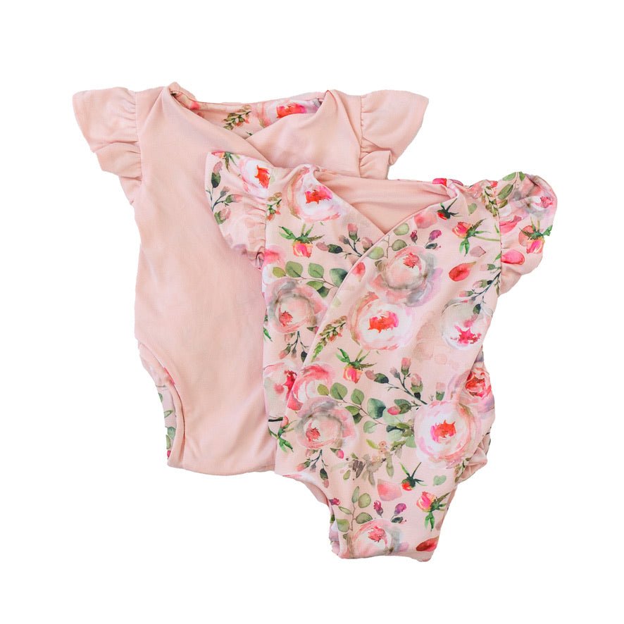 Reversible flutter sleeve baby onesie in peachy lilac design.