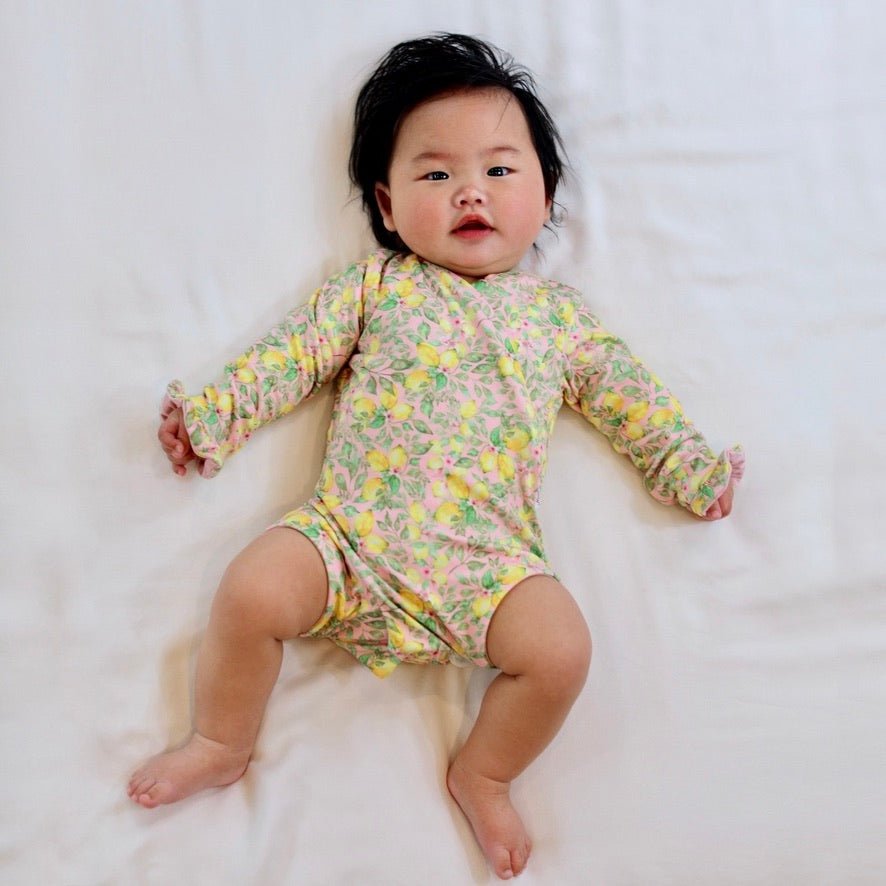 Long sleeve winged baby bodysuit featuring ruffle cuffs in soft Pink Lemonade design brushed fabric.