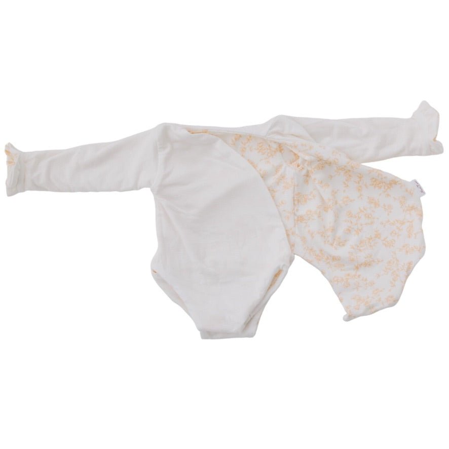 Reversible long sleeved winged bodysuit for babies in silky modal fabric with ruffle cuffs.