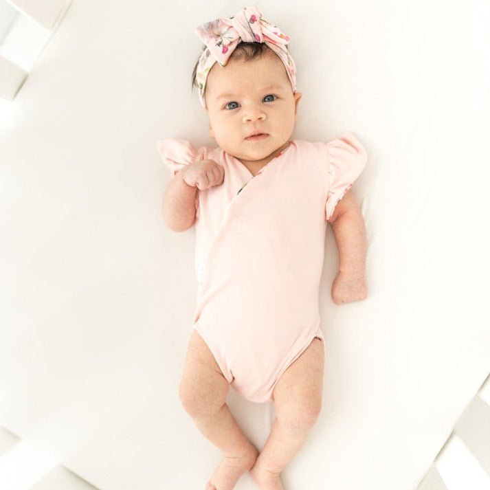 Reversible boutique baby bodysuit in Peachy Rose Fields print and Classic Brushed fabric styles.