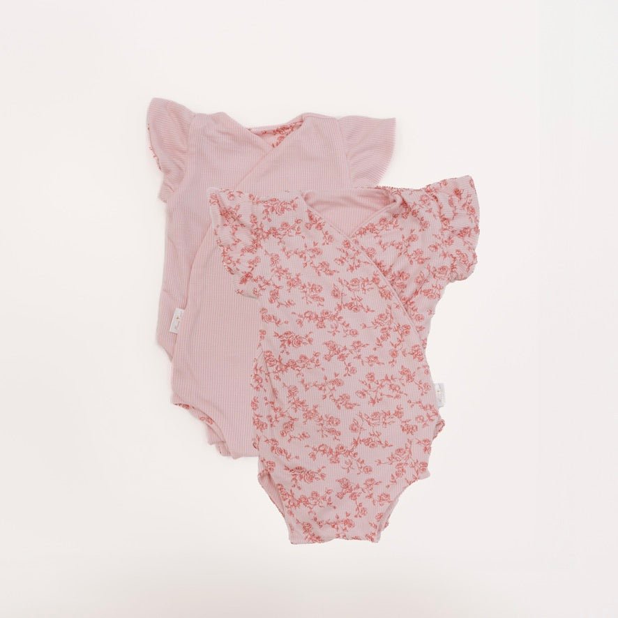 Reversible flutter sleeve baby onesie in bitty pink blooms design.