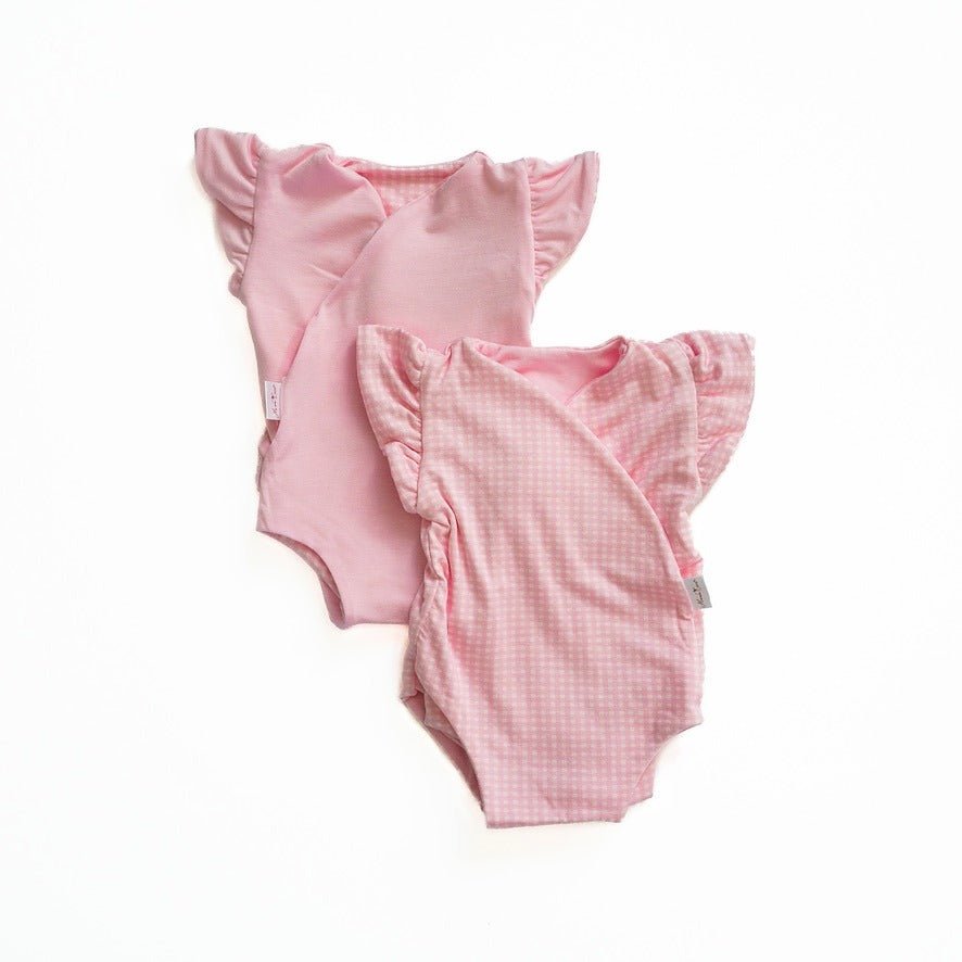 Reversible flutter sleeve baby onesie in baby pink gingham design.