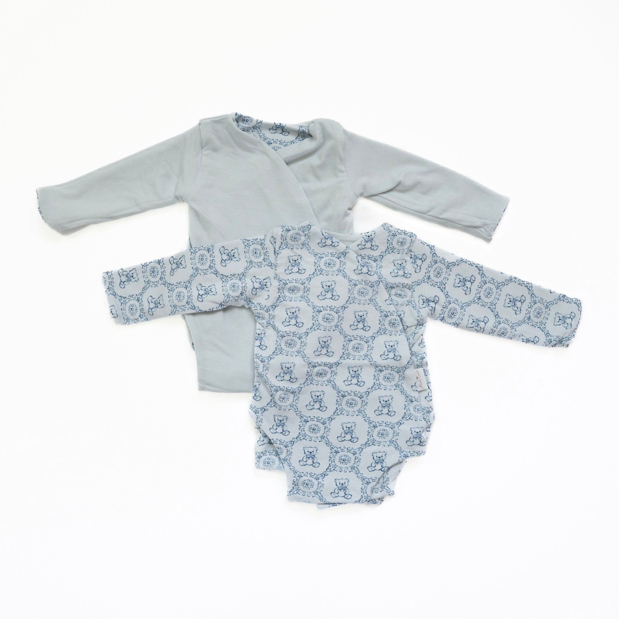 Reversible long-sleeve baby onesie in teddy tiles design.