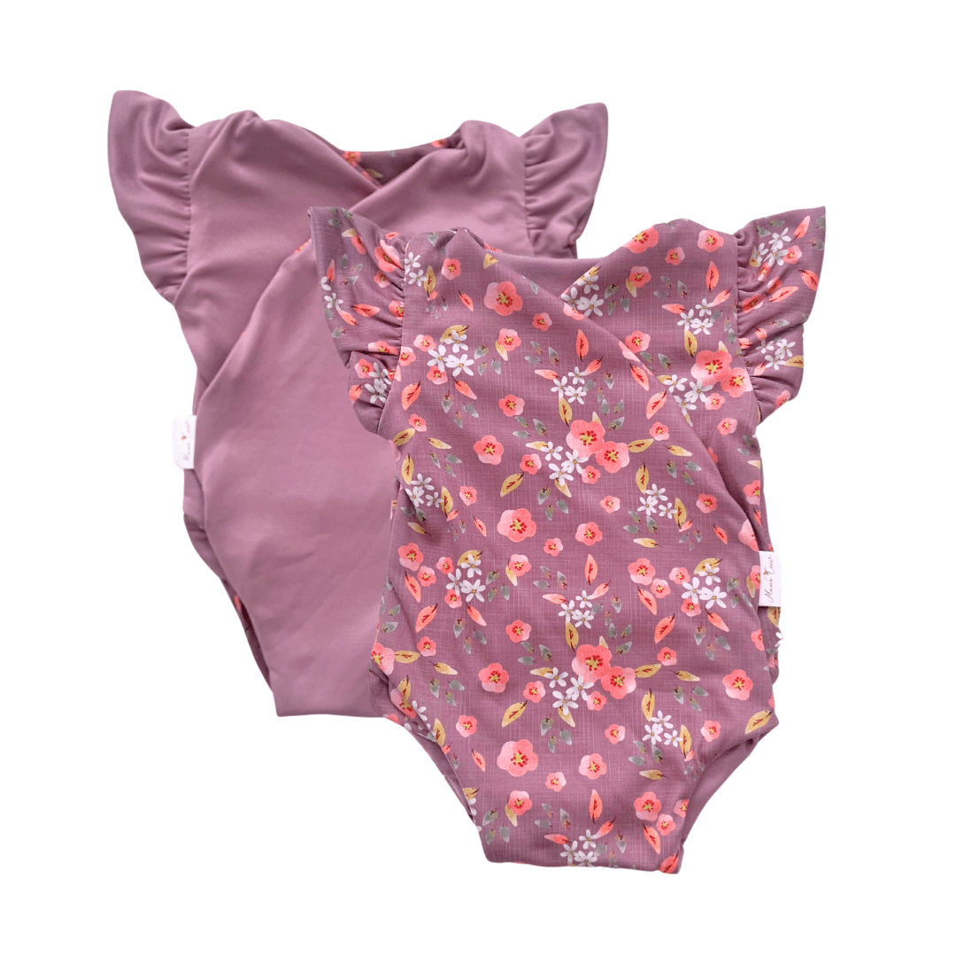 Reversible peachy lilac design flutter sleeve baby onesie in classic brushed fabric.