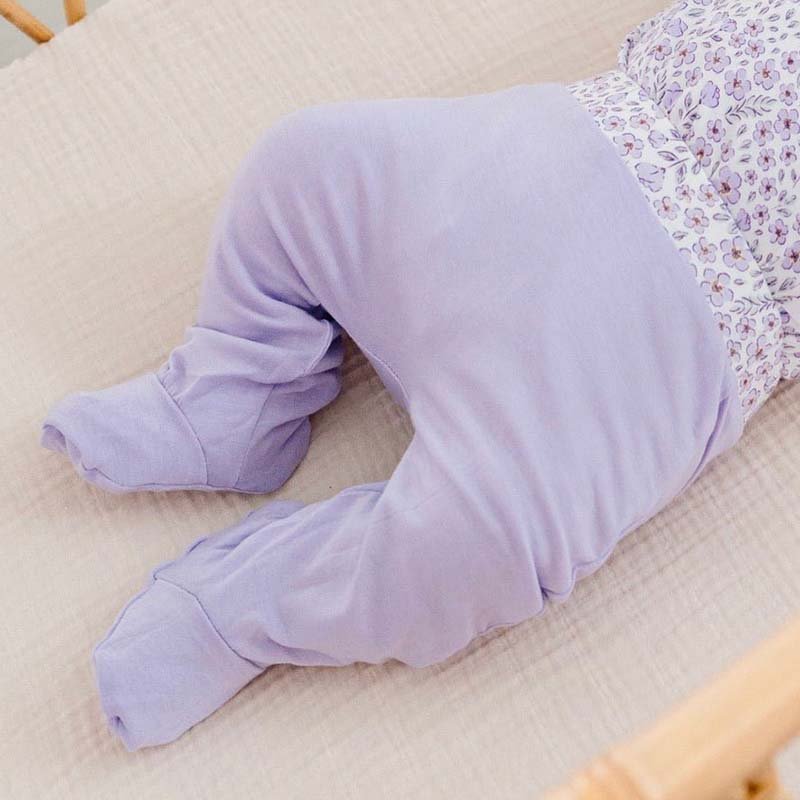 Reversible baby footie pants crafted from a soft silky modal fabric featuring the Purple Posies print.