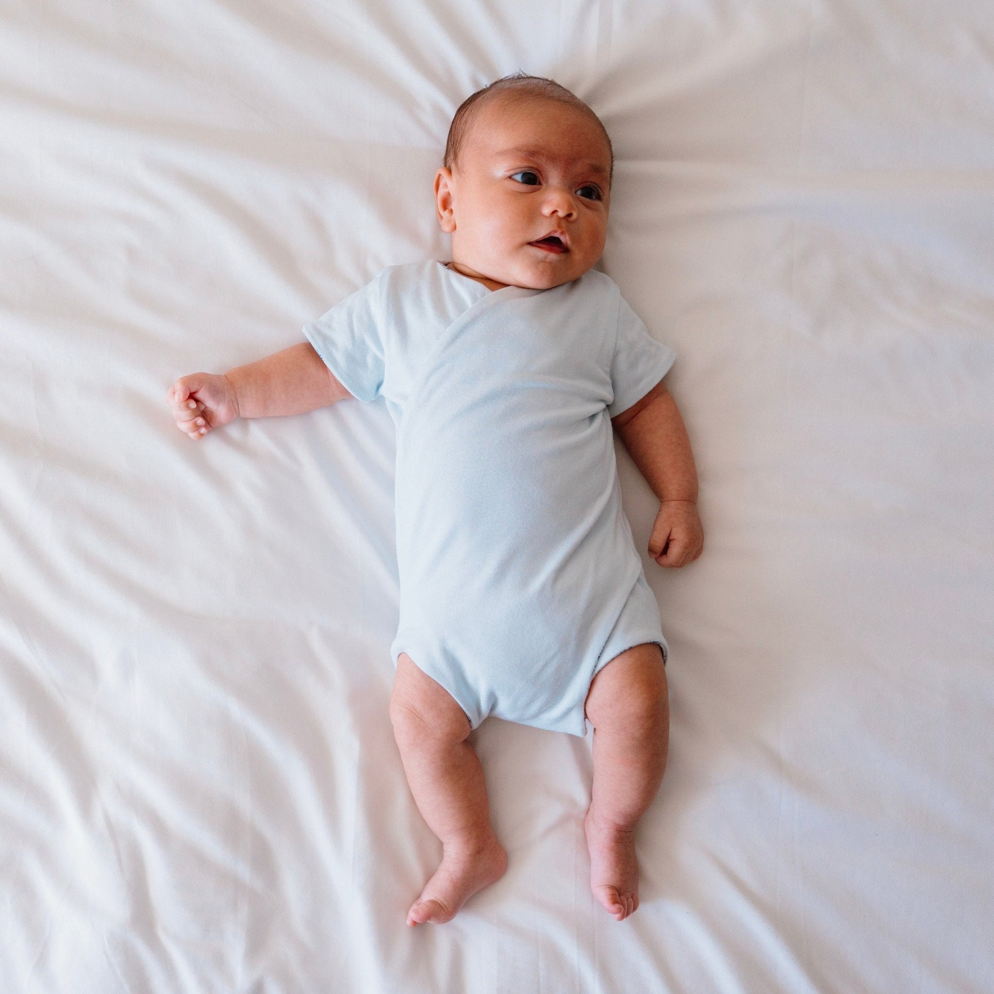 Reversible short-sleeve baby onesie in teddy tiles design.