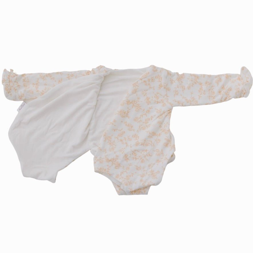 Reversible Bitty Blooms design ruffle cuff long sleeved winged bodysuit in silky modal fabric.