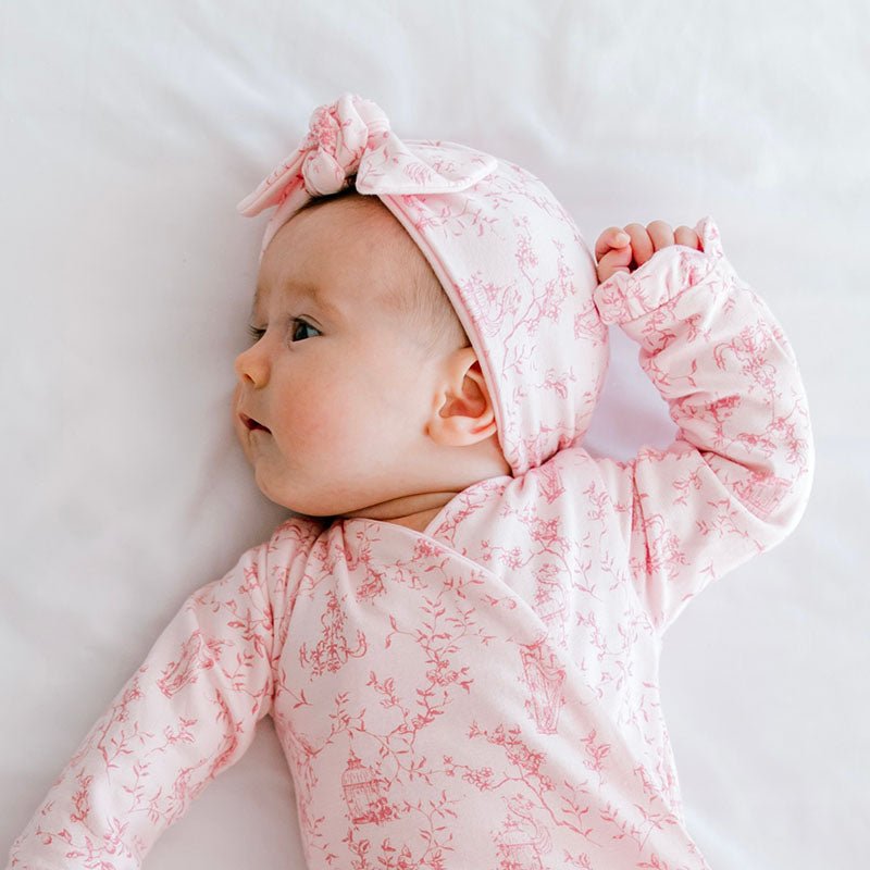 Reversible baby beanie with ruched bow in whimsical garden design.